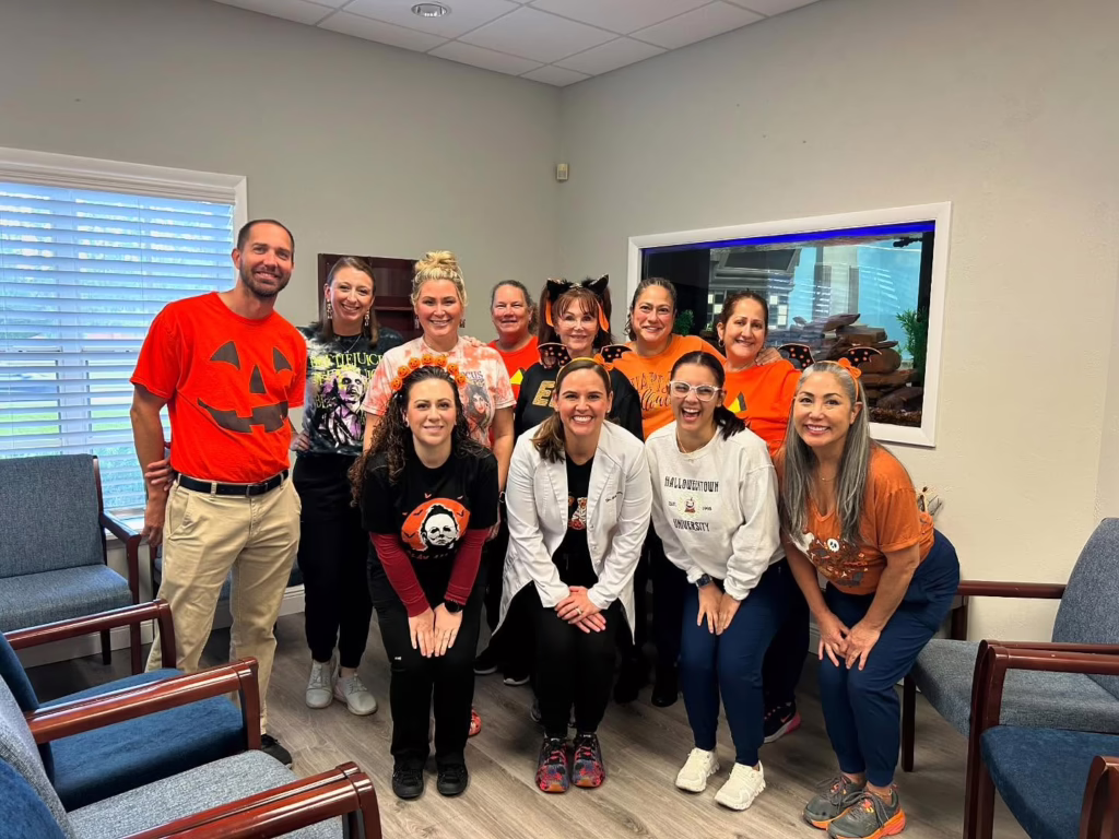 Wiewiora & Dunn Orthodontics team on Halloween, smiling in office, Happy Halloween