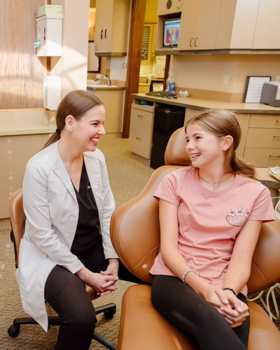 Dr. Wiewiora and child patient in exam chair, smiling